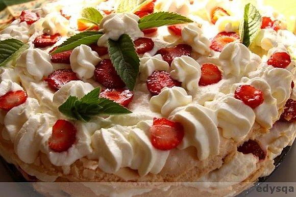 Tort bezowy z bitą śmietaną i truskawkami