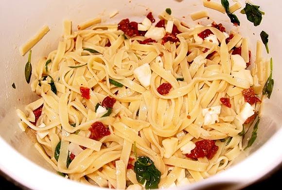 Tagliatelle z suszonymi pomidorami, szpinakiem, mozzarellą i orzechami