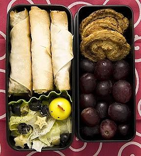 Bento z zawijaskami z ciasta jufka, sałatą i słodkimi przekąskami