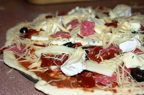 Domowa pizza z serem, salami i oliwkami