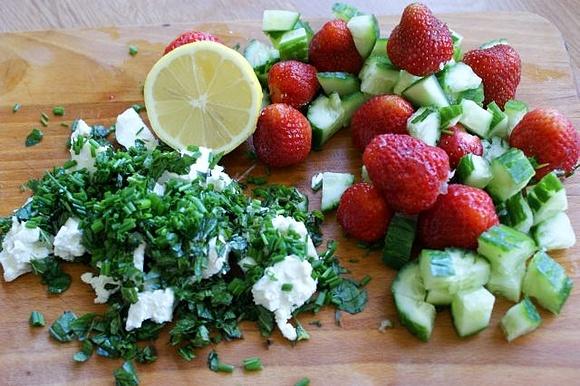 Feta, ogórki, truskawki i zioła na desce