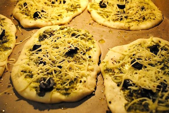 Mini pizze z zielonym pesto i czarnymi oliwkami