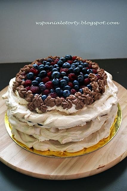 Kawowy tort bezowy z owocami i czekoladowymi dekoracjami