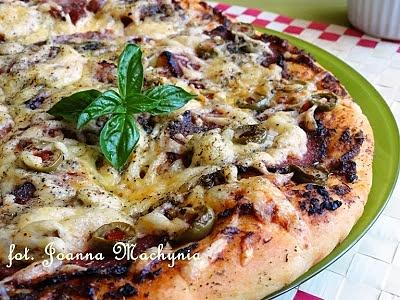 Pizza z czerwonym pesto, salami i oliwkami