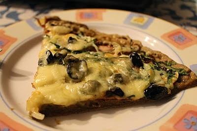 Razowa pizza z roccolą, czarnymi oliwkami i kaparami