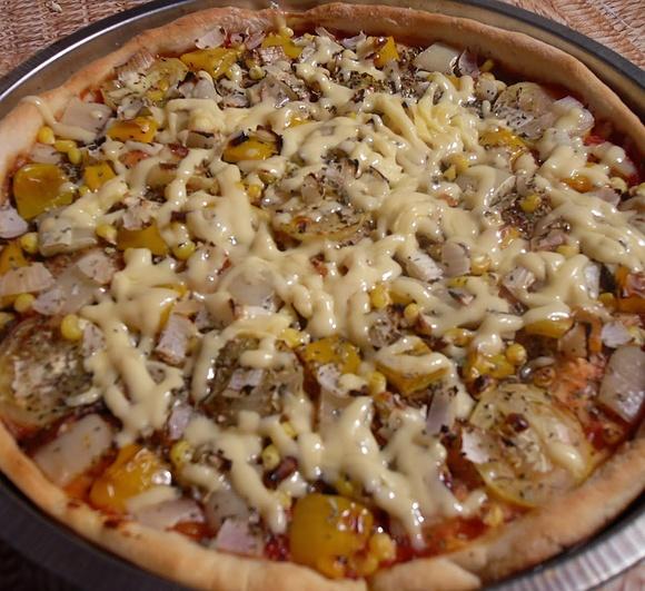 Żółta pizza z warzywami i serem