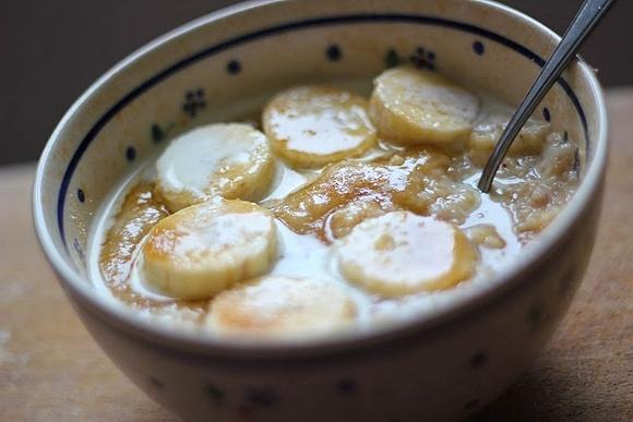 Zimowe śniadanie owsianka z brązowym cukrem śmietanką i bananami