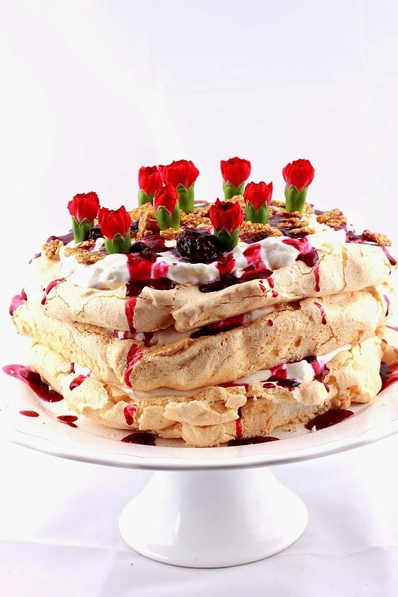 Tort bezowy Pavlova z kremem waniliowym i sosem z owoców leśnych