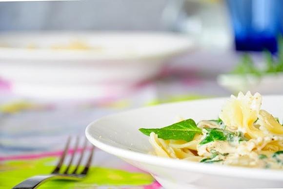 Makaron farfalle z aksamitnym sosem z mascarpone, szpinaku i karmelizowanej cebuli