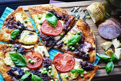 Pizza na pełnoziarnistym cieście z pesto, kiełbasą, oscypkiem i warzywami