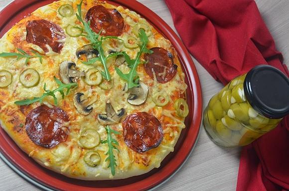Pizza z oliwkami chorizo i świeżą rukolą