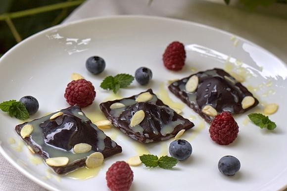 Czekoladowe ravioli z serem, malinami, borówkami i sosem czekoladowym