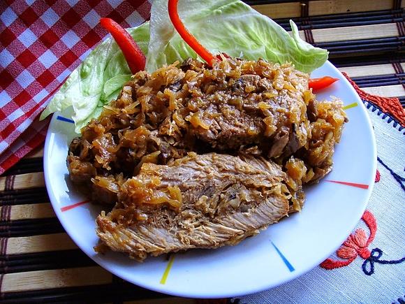 Karkówka pieczona w kapuście kiszonej z pieczarkami