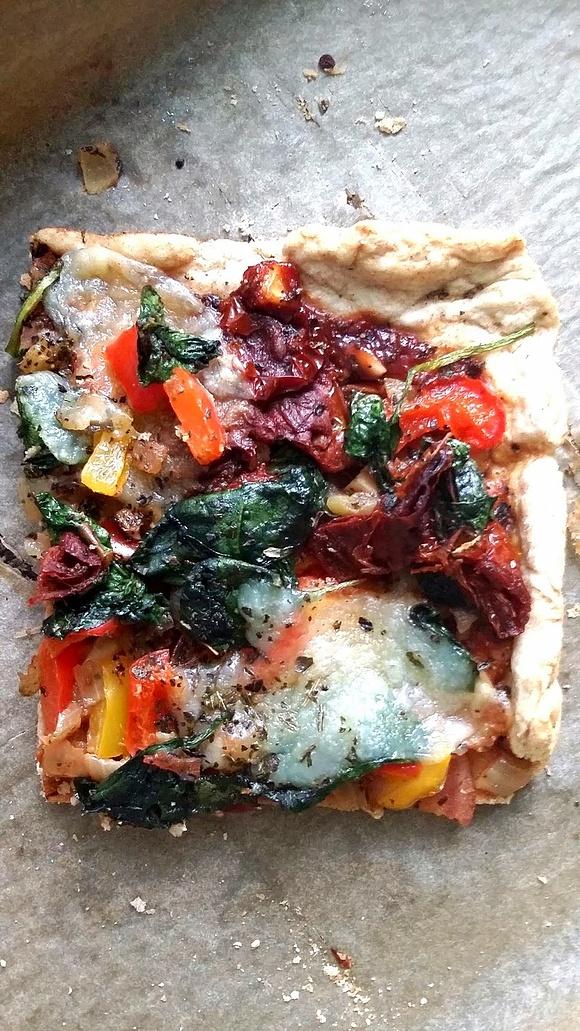 Pizza z mocarellą, szpinakiem, suszonymi pomidorami i papryką