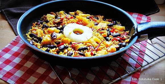 Młody gotuje ryż curry z papryką, ananasem i kukurydzą