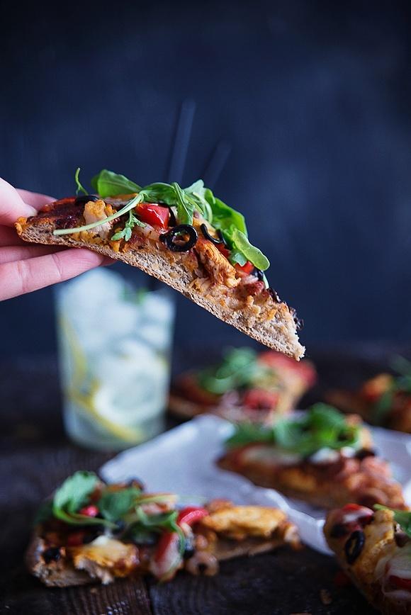 Pizza razowa z kurczakiem oliwkami mozzarellą i rukolą