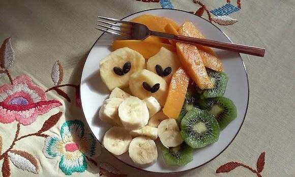 Talerz owoców banan, jabłko, kiwi, mango z pestkami dyni
