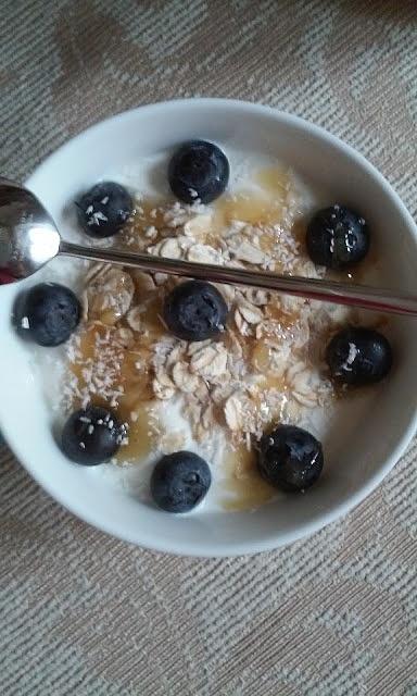 Jogurt grecki z płatkami owsianymi miodem borówką i wiórkami kokosowymi