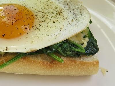 Grillowana kanapka z maślanym czosnkowym szpinakiem, serem i jajkiem sadzonym