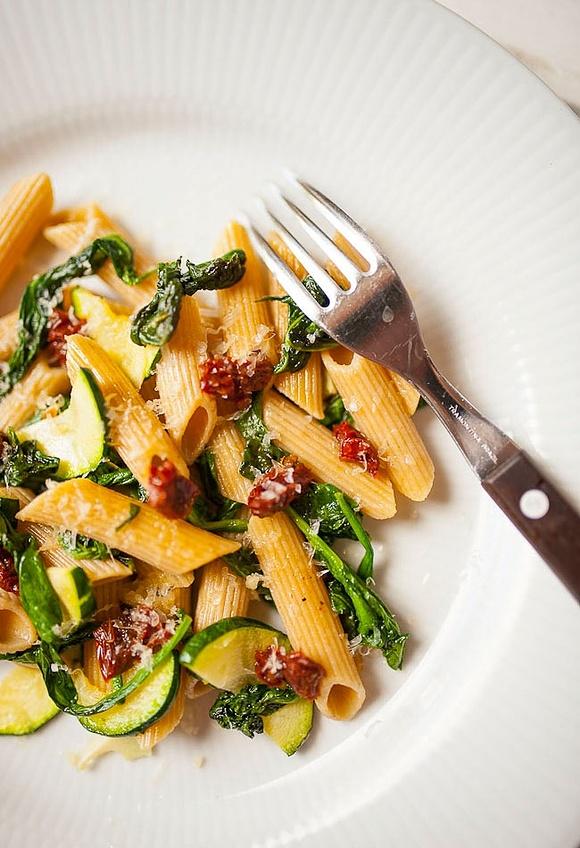Pełnoziarnisty makaron penne z cukinią, szpinakiem i suszonymi pomidorami