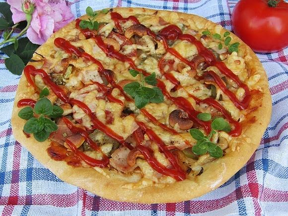 Pizza z szynką pomidorem ogórkiem kiszonym i orzechami nerkowca