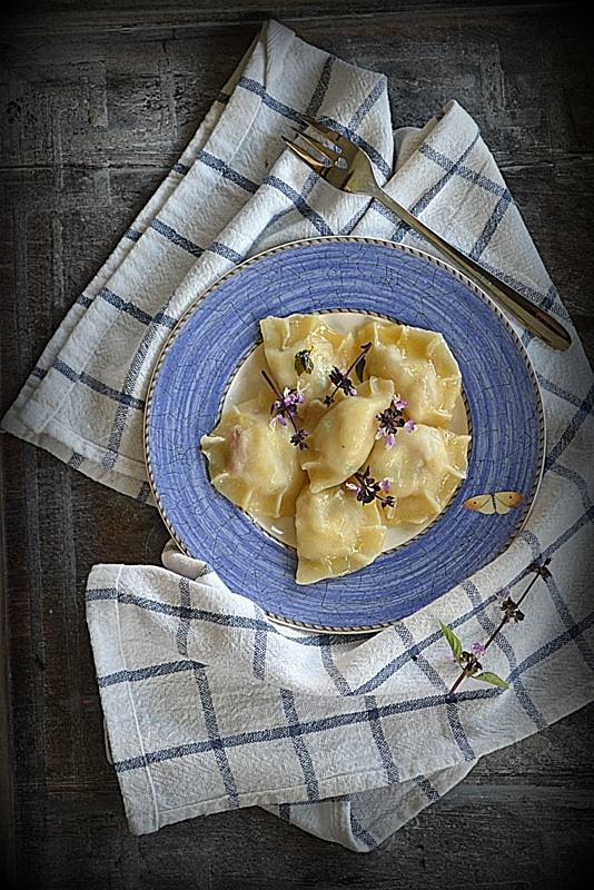 Wędzony pstrąg z twarogiem, ziołami i kwiatami szałwii w pierogach