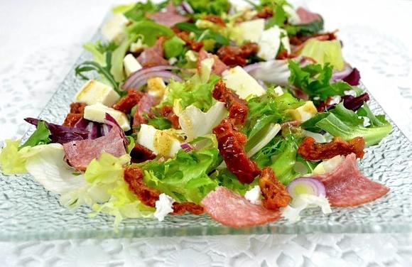 Sałatka z mixem sałat, salami, suszonymi pomidorami i mozzarellą