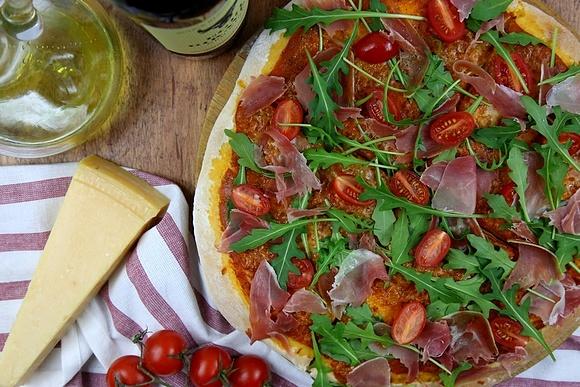 Pizza z szynką parmeńską, pomidorkami, rukolą i sosem z czerwonym winem