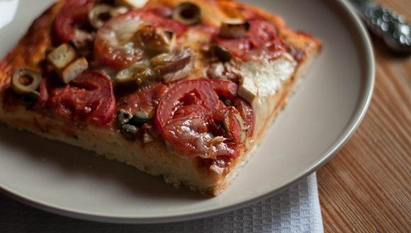 Domowa pizza z tuńczykiem, serem owczym i pomidorami na cienkim cieście
