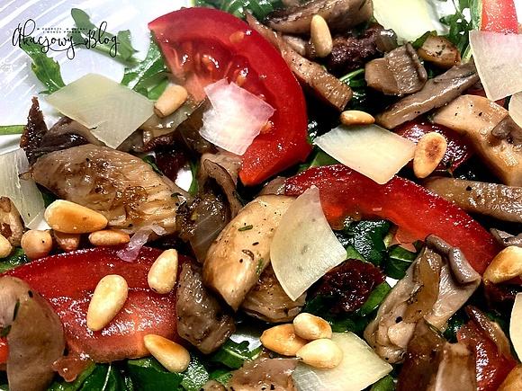 Rukola z boczniakami pomidorami parmezanem i orzeszkami pinii