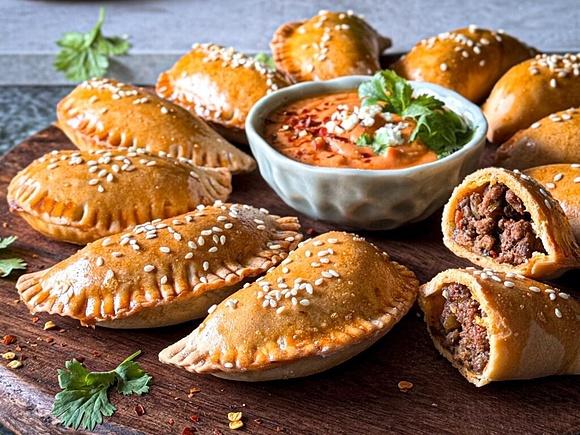 Empanadas z wołowiną i duszonymi warzywami z dipem pomidorowym i fetą