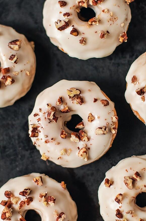 Wegańskie pieczone donuty dyniowe z pomarańczowym lukrem i orzechami pekan