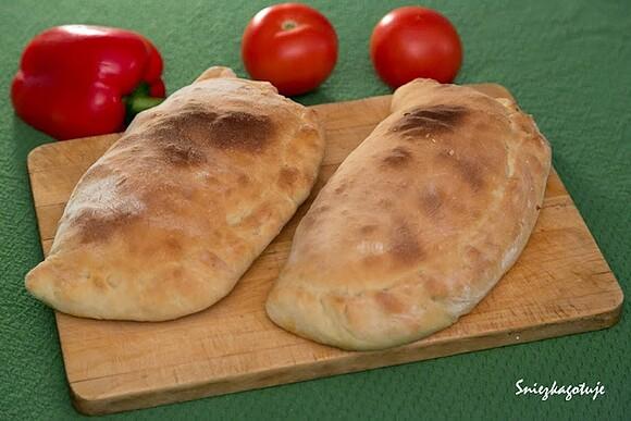 Pizza calzone z mięsem i czarnymi oliwkami