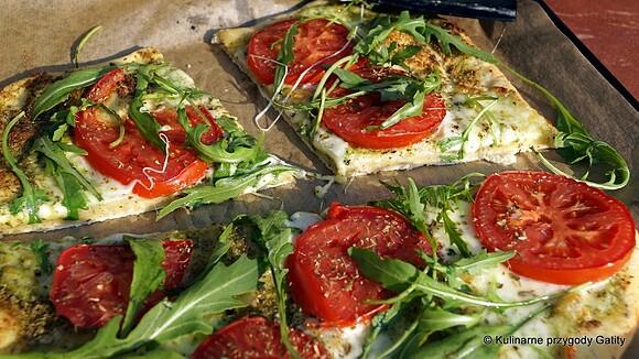 Pizza z mozzarellą pomidorami i rukolą