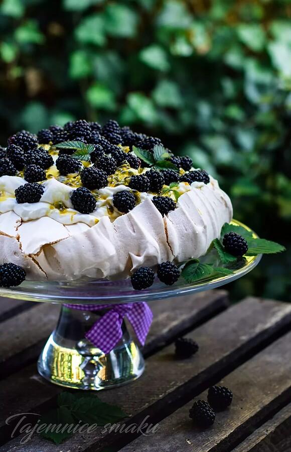Tort bezowy pavlova z bitą śmietaną jeżynami i marakują